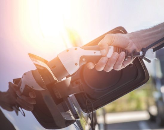 Color image of a man's hand preparing to charge an electric car.; Shutterstock ID 456984208